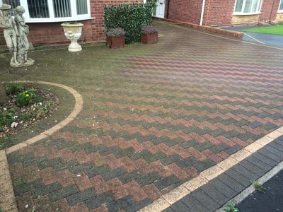 block paving covered in weeds